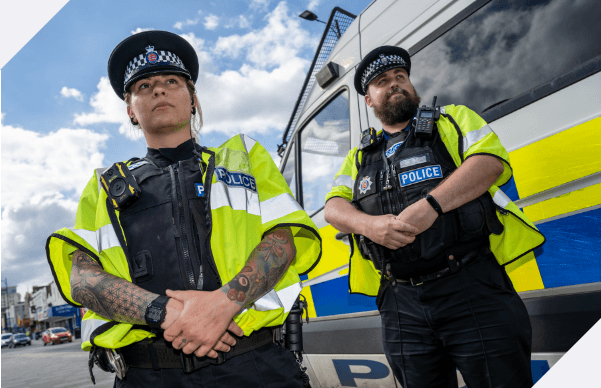 Two police officers standing next to a police van