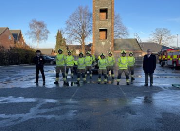 Eight new firefighters lined up at their passout ceremony. Chief Fire Officer Rick Hylton and PFCC Roger Hirst are either side of them.