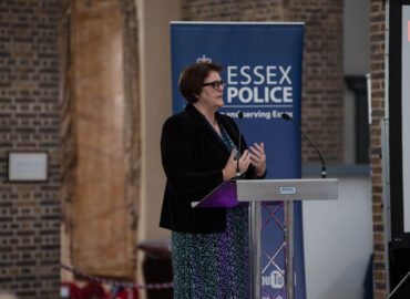 Deputy PFCC Jane Gardner hosting the conference. She is standing in front of an Essex Police logo.
