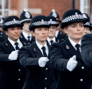 Female police officers marching in front of Police HQ in uniform during their passout ceremony.